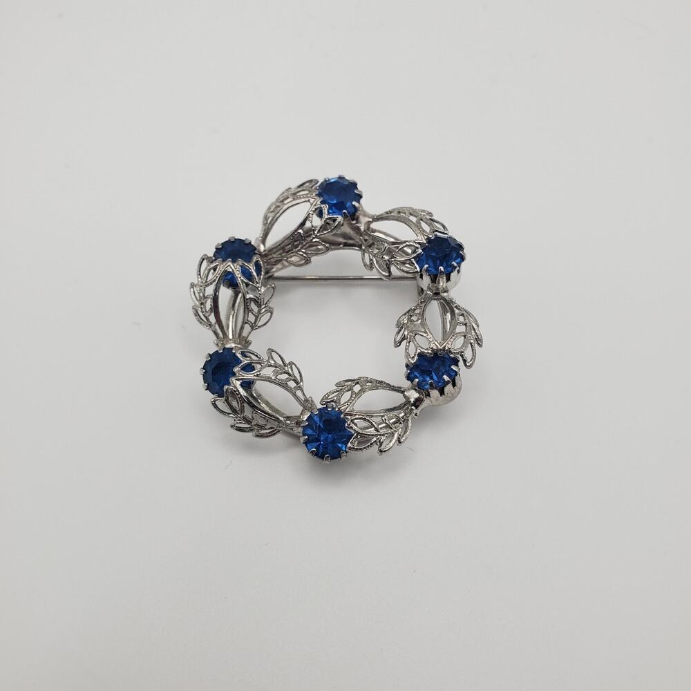 Vintage Unsigned Bright Blue Rhinestone Silver Tone Leaved Circle Brooch